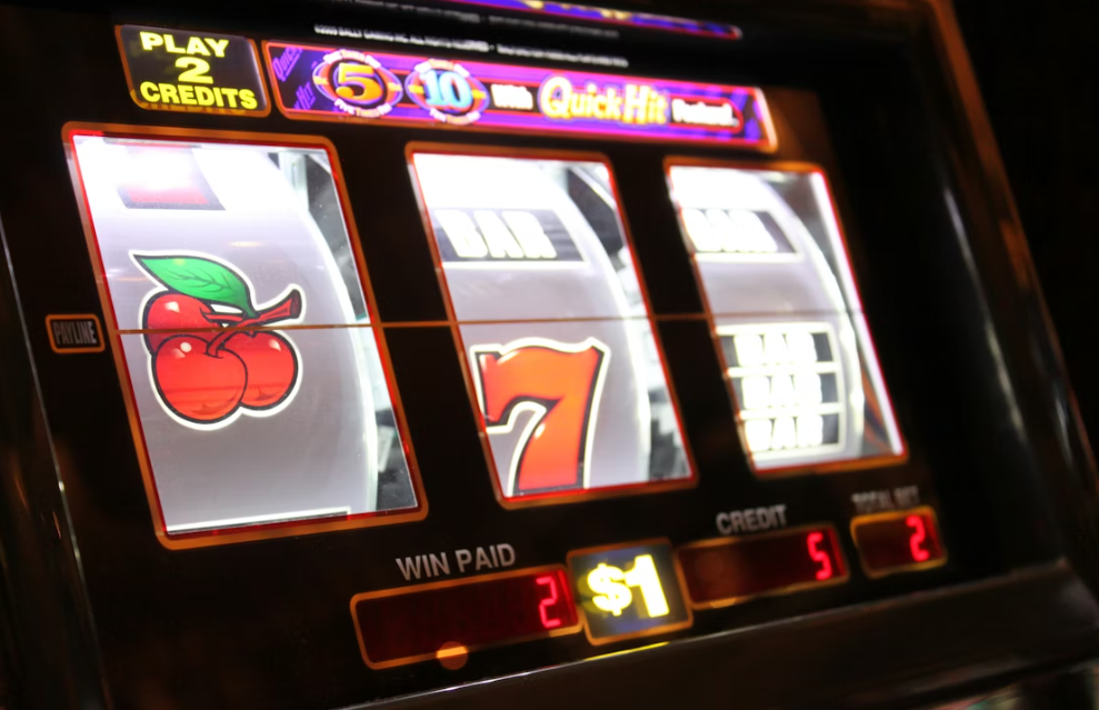 A close-up of a slot machine with cherries and sevens on the reels, showing a $1 credit
